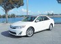 New Camry is wider and lower, with headlights that merge into the bumper cover and taillight clusters that wrap into the body sides and into the trunk.