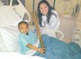 Jillian Roberts, who recently carried the Olympic Torch on its journey through London, visits with one of the pediatric patients at Baptist Children’s Hospital.
