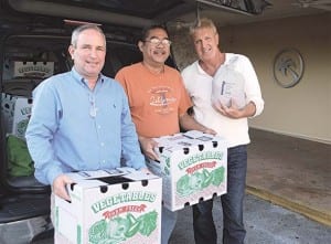 Pictured (l-r) at Village Hall, Vice Mayor-Elect John Dubois, Dale Danks of Christ Fellowship Church and Councilmember Patrick Fiore pack Publix donated turkeys into