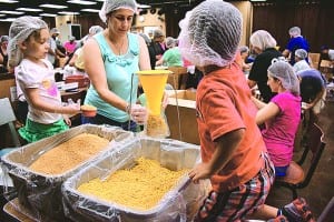 Hundreds of volunteers pack meals for families in need
